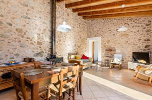 a living room with a table and chairs and a fireplace at YourHouse Son Tey Villa in Sineu