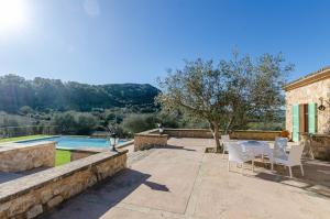 a patio with a table and chairs and a pool at YourHouse Son Tey Villa in Sineu