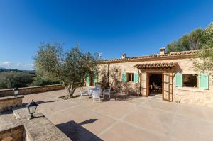 an outdoor patio with tables and chairs in front of a building at YourHouse Son Tey Villa in Sineu