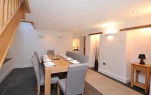 een eetkamer met een houten tafel en stoelen bij Revelstoke Park House in Noss Mayo