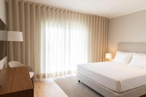 Un dormitorio con una cama y una ventana grande. en Blank - Alojamento Local, en Santo Estêvão