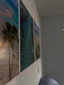 a wall with pictures of a beach and a palm tree at Apartamento Maragogi - CENTRO in Maragogi