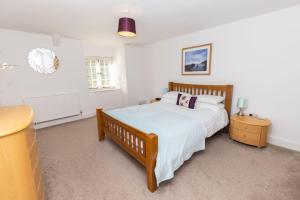 a bedroom with a large bed and a dresser at Revelstoke Park House in Noss Mayo