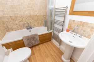 een badkamer met een wastafel, een bad en een toilet bij Revelstoke Park House in Noss Mayo +32 foto's
