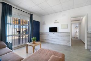 a living room with a couch and a tv at Casa la Viña in Chiclana de la Frontera