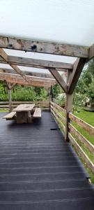 a wooden pergola with a picnic table and a fence at Shanti ghar house in Cork