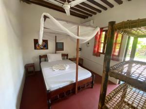 a bedroom with a canopy bed and a bunk bed at Oasis Bungalows in Jambiani