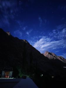 zoz Aryan Valley في Dah: اطلالة بالليل على جبل وامامه بيت