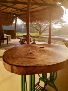 a large wooden table with green legs under a pavilion at Sigiriya Elegant Resort in Sigiriya