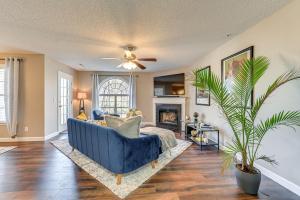 a living room with a blue couch and a fireplace at Winston-Salem Condo with Balcony Steps to Golf! in Winston-Salem