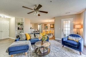 a living room with blue furniture and a ceiling fan at Winston-Salem Condo with Balcony Steps to Golf! in Winston-Salem