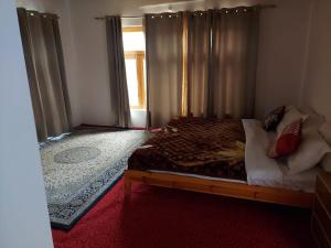zoz Aryan Valley في Dah: غرفة نوم بسرير ونافذة مع ستائر