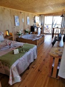 Großes Zimmer mit einer Badewanne und einem Schlafzimmer. in der Unterkunft NewViejoBlanco in Punta Del Diablo