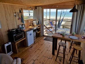 eine Küche mit einem Tisch und eine Küche mit Blick auf den Strand in der Unterkunft NewViejoBlanco in Punta Del Diablo