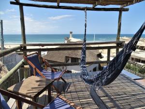 2 Stühle und eine Hängematte auf einer Terrasse mit Strand in der Unterkunft NewViejoBlanco in Punta Del Diablo