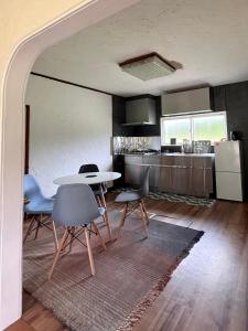 a kitchen with a table and chairs in a room at Sound Garden Biei, Cricket in Biei