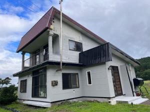 a white house with a red roof at Sound Garden Biei, Cricket in Biei