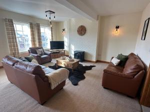 a living room with two couches and a tv at Riverside in Brecon