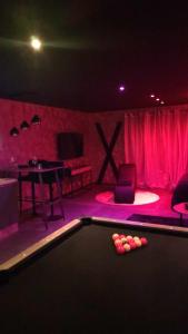 una mesa de billar en una habitación con iluminación rosa en La Secrète en Barlin