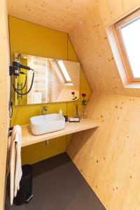 a bathroom with a sink in a wooden house at Glamping Alvearium Alturis in Gagliano
