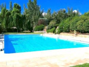 una gran piscina azul en un patio en Casa Sierra norte de Madrid, en Navalquejigo