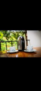 two coffee cups and a toaster on a wooden table at River Edge Safari House in Udawalawe