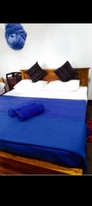 a bedroom with a bed with blue sheets and pillows at River Edge Safari House in Udawalawe