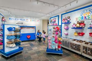 un niño parado frente a una tienda con animales de peluche en Great Wolf Lodge Kansas City en Kansas City