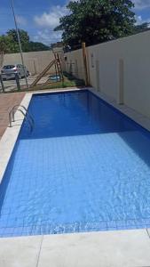 une grande piscine bleue dans une maison dans l'établissement Apartamento 02 quartos para o Carnaval - Olinda, à Olinda