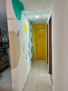 un couloir avec une porte jaune dans une cuisine dans l'établissement Apartamento 02 quartos para o Carnaval - Olinda, à Olinda