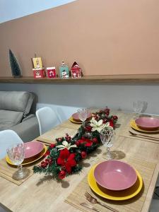 une table avec des assiettes roses et jaunes et des décorations de Noël dans l'établissement Apartamento 02 quartos para o Carnaval - Olinda, à Olinda