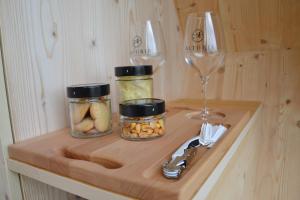 un estante con dos tarros de comida y una copa de vino en Glamping Alvearium Alturis en Gagliano