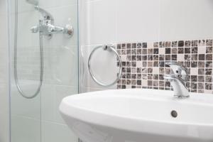 a bathroom with a sink and a shower with a mirror at Primula Accommodation in Nova Gorica