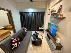 ein Wohnzimmer mit einem Sofa und einem Flachbild-TV in der Unterkunft Romantic Sun Set View Apartment in Port Dickson