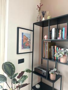 a black book shelf with books and a plant at Hygge Studio in Rome