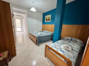 ein Schlafzimmer mit 2 Betten und einer blauen Wand in der Unterkunft Da Bosio in Genga