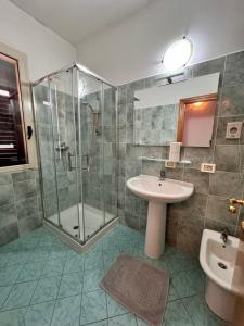 a bathroom with a glass shower and a sink at Da Bosio in Genga