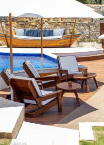 a group of chairs and an umbrella next to a pool at Le Relais La Borie in Búzios