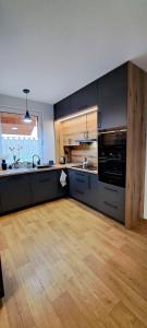 una grande cucina con pavimenti in legno e una cucina con piano cottura di Noclegi u Lidki 