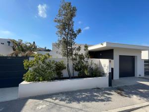 una casa bianca con un albero di fronte di Oasis Blue Perpignan Canet a Perpignano