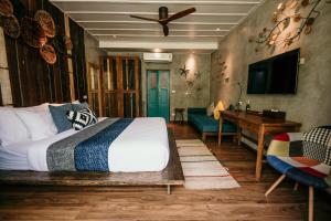 a bedroom with a bed and a desk and a television at Sand in My Shoes Beach Loft in Thong Nai Pan Noi