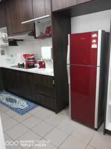 a kitchen with a red refrigerator in a kitchen at JANNAH HOMESTAY ii in Putrajaya