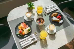 a table with plates of food and cups of coffee at Hotel Villa Dirce in Limone sul Garda