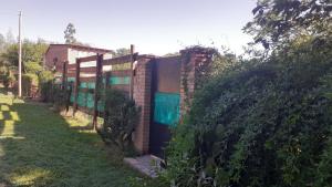 einen Zaun neben einem Haus mit Tor in der Unterkunft CASONA DELVUELO in Unquillo