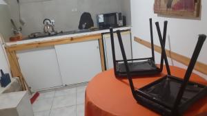 eine Küche mit einem Tisch und einer Mikrowelle in der Unterkunft CASONA DELVUELO in Unquillo