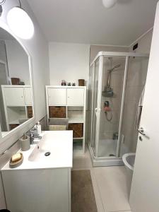 a white bathroom with a shower and a sink at Hygge Studio in Rome