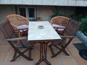 drie stoelen en een tafel met een tafel en een tafel en stoelen bij Casa La Montaña in Las Navas del Marqués