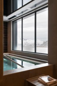 una piscina en una habitación con ventana en Résidence Le Hameau de l'Ours, en Manigod