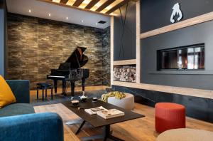 een woonkamer met een piano en een tafel bij Résidence Le Hameau de l'Ours in Manigod