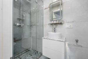 a white bathroom with a sink and a shower at Motława River Old City Gdańsk Apartment by Renters in Gdańsk